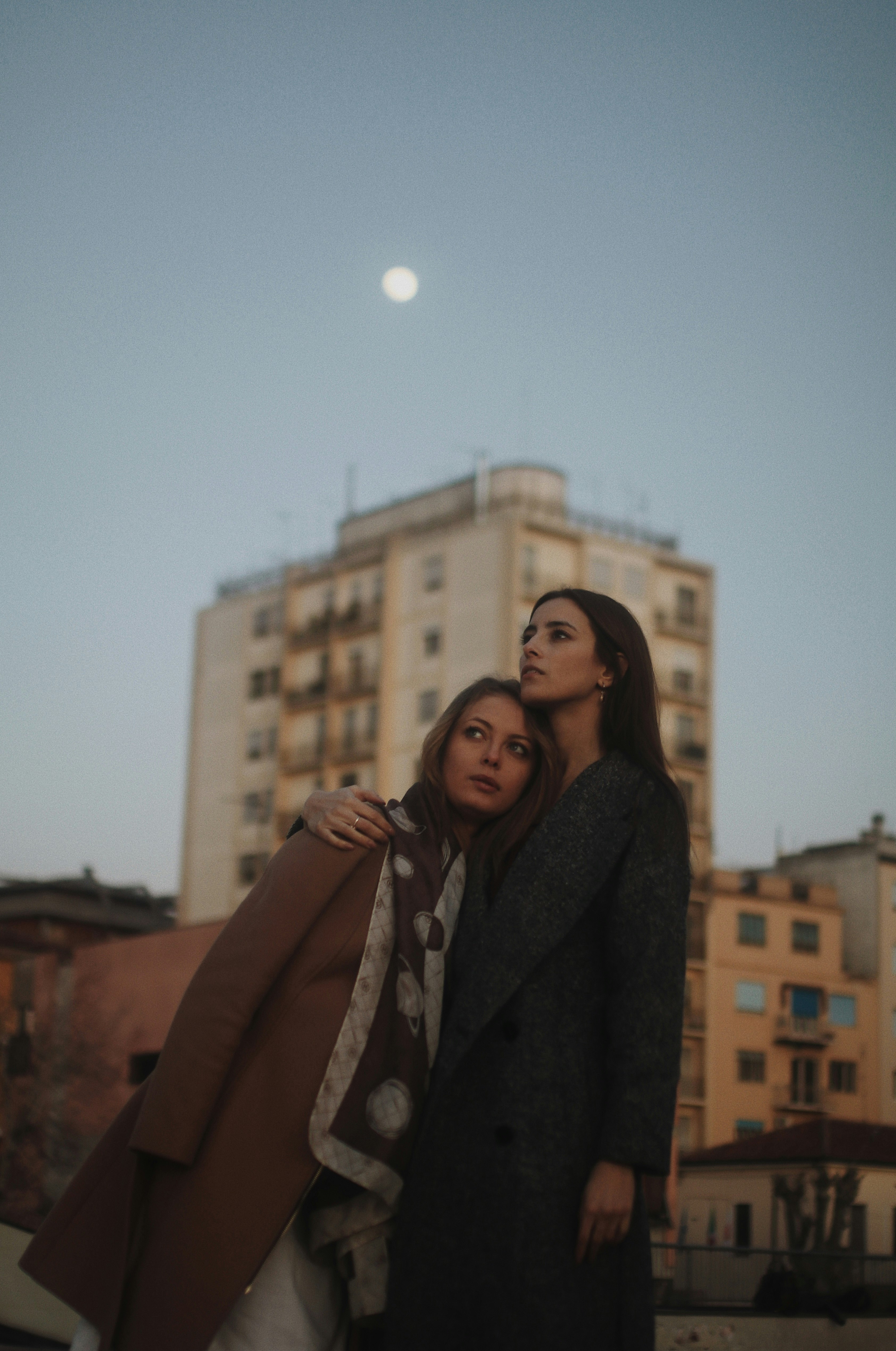 woman in brown coat standing near building during daytime